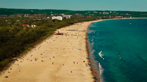 Sandy Beach Stretching Along Turquoise Sea Coastal Shoreline Filled with Relaxing People Blue Ocean