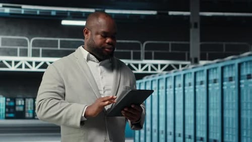 Smiling Data Center Technician Installing Server Racks Systems Using Tablet