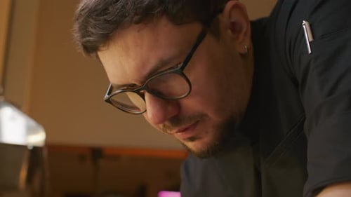 Professional Chef Writing Order Notes in Restaurant Kitchen