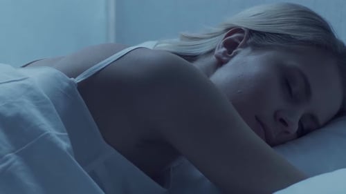 Blonde Woman Asleep Peacefully in Her Bed at Night