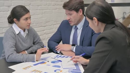 Diverse Colleagues Discussing Data in Modern Office