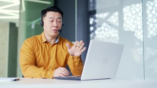 Man With Headset Talking to Computer in Office
