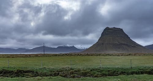 time lapse of Kirkjufell Mountain with clouds mountains on background