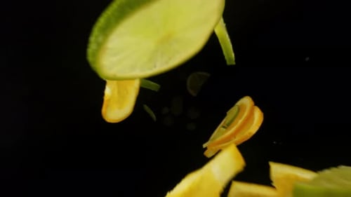 Bottom View Isolated Slow Motion Macro Shooting Capturing Lots of Green Lime and Orange Slices