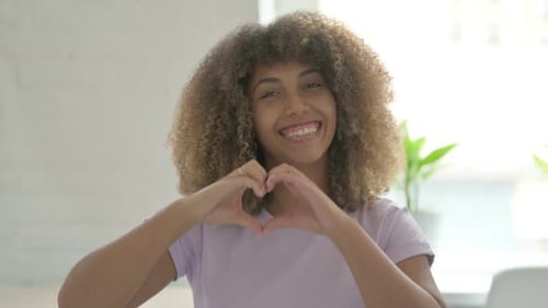 Smiling Woman Makes Heart Shape With Hands