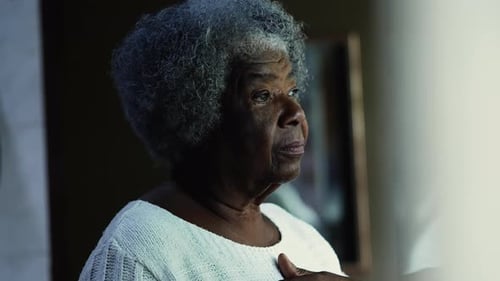 Thoughtful Senior Woman Looking Out Window