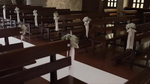 Church pews decorated for wedding ceremony