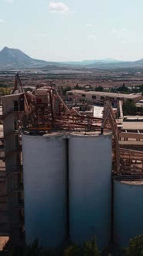 Abandoned Cement Factory with Large Silos and Rusty Industrial Structures