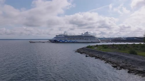 Forwards Fly Along Sea Coast Heading Towards Big Cruise Ferry Ship at Pier View Against Clouds in