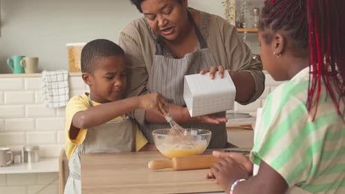 Woman and Children Baking Together in Kitchen