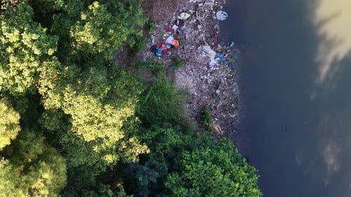 Aerial view of polluted river and trash filled banks