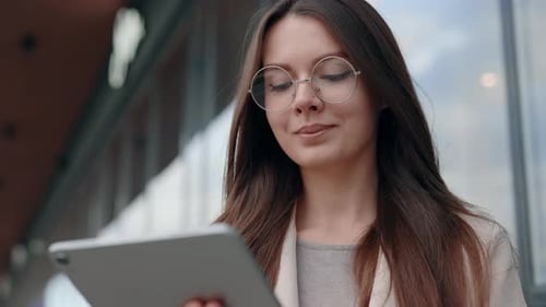 Caucasian Attractive Positive Businesslady Wearing Glasses Using Digital Tablet and Checking Social