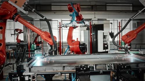 Des robots multibras automatisés travaillent de concert pour souder des châssis métalliques avec précision et synchronisation