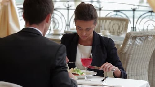 Businesswoman Enjoying a Meal with a Businessman at a Fine Dining Restaurant