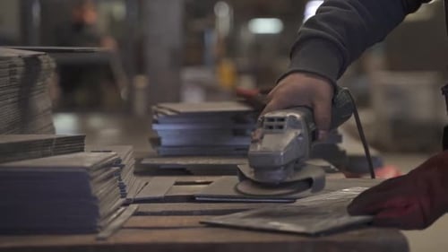 Arbeiter benutzt Schleifmaschine in der Fabrik an Metallteilen. Zeitlupe.