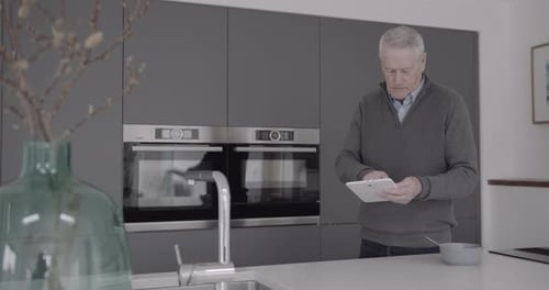Man Uses Tablet in Modern Kitchen