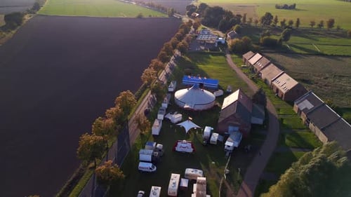 Small village with traveling circus tent at golden hour with long shadows.
Perfect aerial view fligh