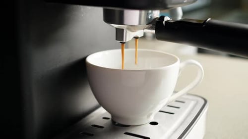 Pouring Coffee Stream From Machine in Cup