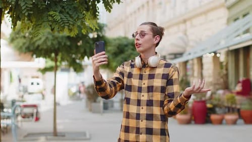 Blogueiro alegre tirando selfie no smartphone comunicando uma videochamada on-line com assinantes