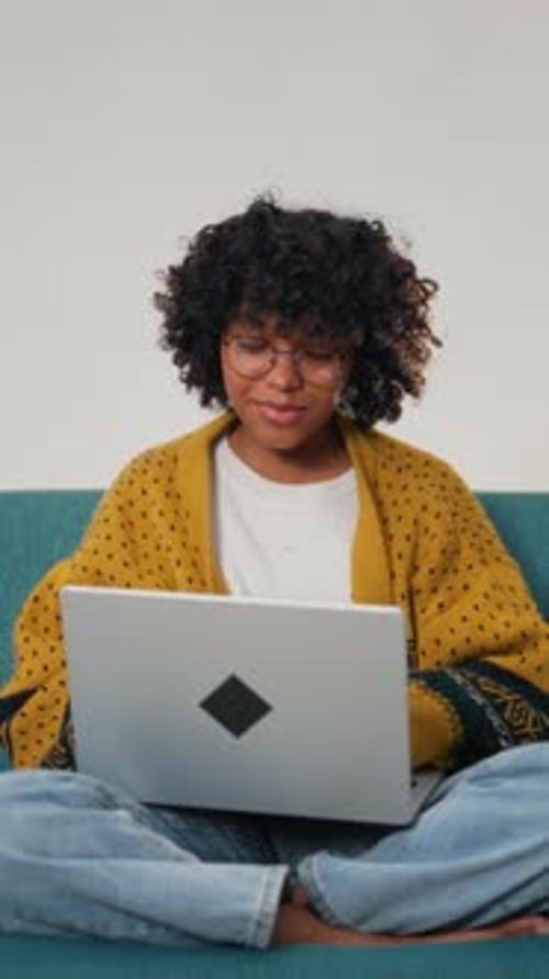 Pretty African American Student Working with Laptop in Apartment Freelance and Surfing Internet
