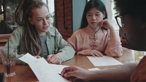 Group of Friends in Restaurant Suggesting Dishes and Deciding on their Order
