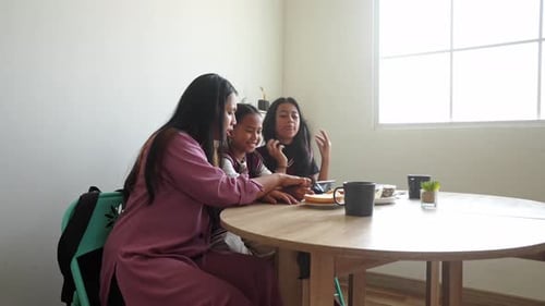 Asian Little Girl Wearing School Uniform Playing Games Using Smartphone With Sister And Mother