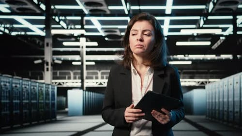 Engineer Walking in Data Center Monitoring Automation Systems Using Tablet