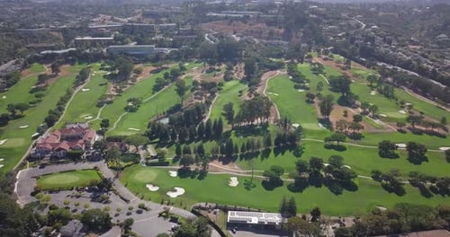 Aerial drone view of Golfing grounds with trees and lush green grass pathways besides the highway