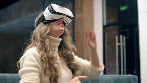 A blonde caucasian woman exploring virtual reality using VR glasses in an office