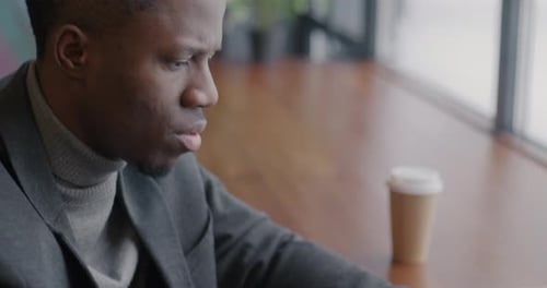 Closeup of African American Businessman Typing with Modern Laptop Working Indoors in Cafe