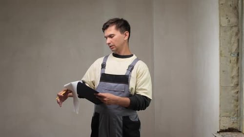 Construction Worker Taking Notes on Clipboard During Home Renovation