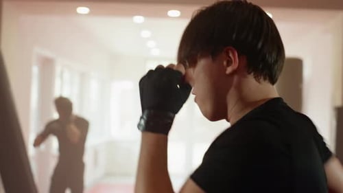 Boxer Wearing Black Sportswear Prepares for Sparring Session Inside Gym