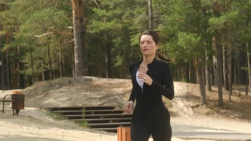 Woman Running in a Park Wearing Black Sportswear