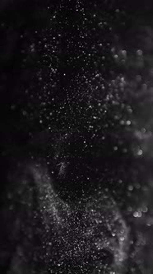 Dust Particles Swirling on the Black Background Vertical Video