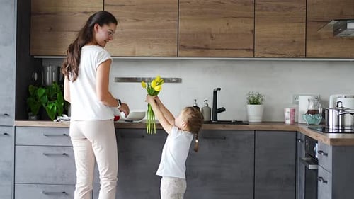 Little Girl Gives Yellow Tulips to Her Mother