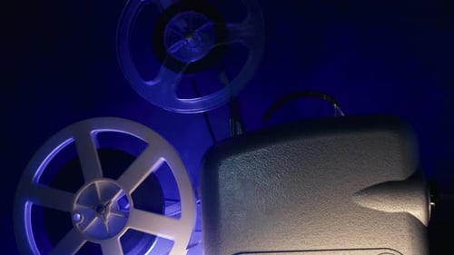 Vintage 8mm Film Projector Reels Turning at Night