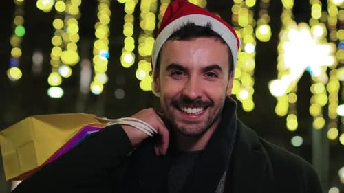 Smiling Man with Shopping Bags and Santa Hat