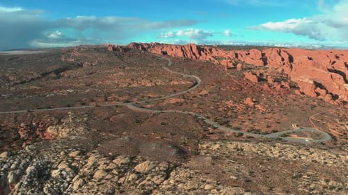 A stunning aerial red rock landscape shot with a bright blue sky in the background and thick storm c