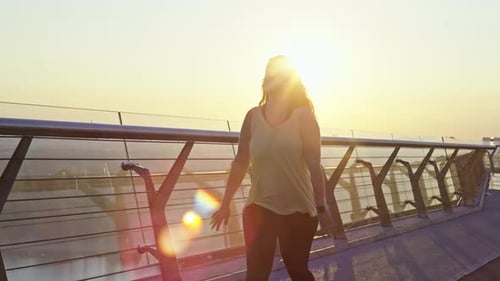 A Beautiful Girl on a Morning Run in the City in the Rays of the Sun