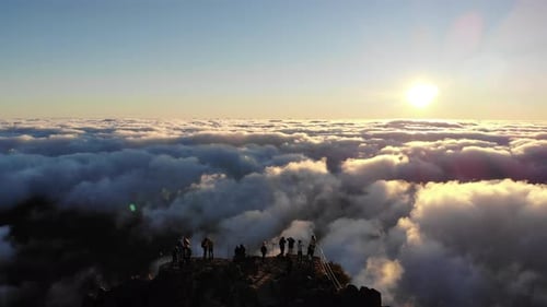 The drone captures the ethereal beauty of sunrise on Pico Areeiro, as clouds swirl around the mounta