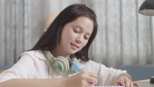 Asian Teenager Studying At Home, Asia Teen Writing While Sitting On The Table