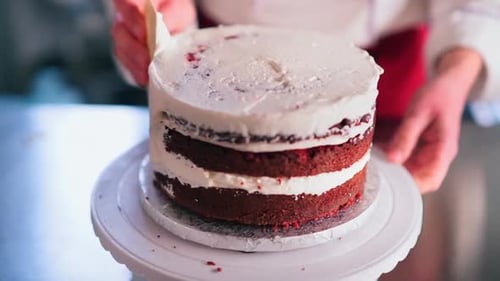 Woman Frosting Delicious Red Velvet Layer Cake