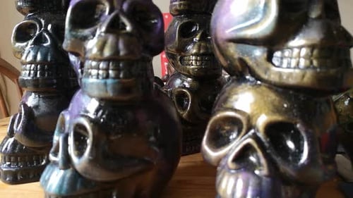 Multicoloured painted ceramic spooky death skull totem crafts pottery ornament closeup dolly left