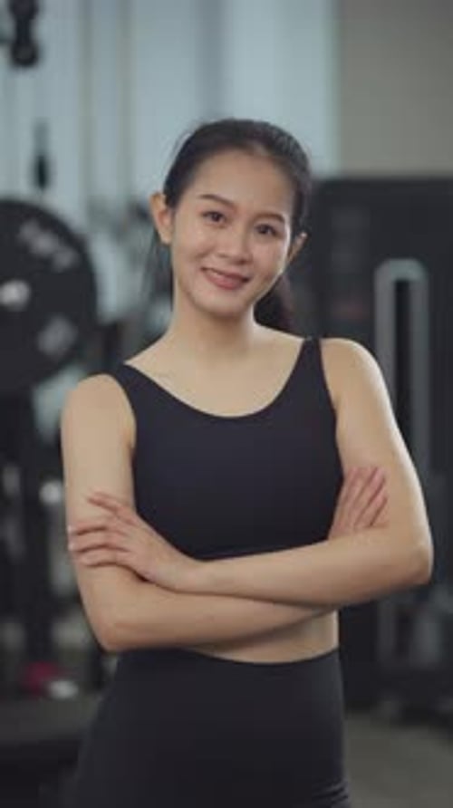 Young Woman Smiling in Gym Wearing Athletic Clothes