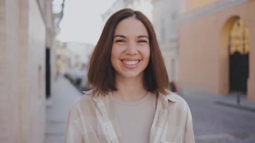Portrait of a Young Beautiful Woman on the Street A Beautiful Girl Looks at the Camera and Smiles A
