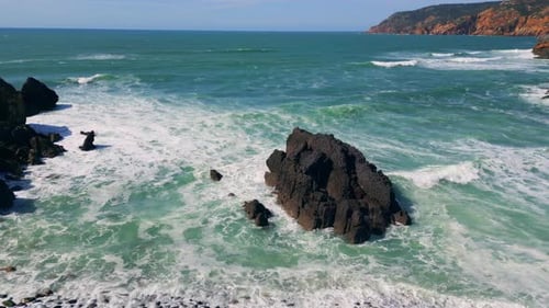 Drone Foamy Waves Rolling on Stony Shoreline in Slow Motion Sea Washing Coast