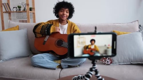 Young Person Plays Guitar for Smartphone Recording