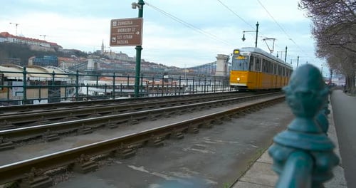 Tramway jaune sur les voies ferrées de la ville à la lumière du soleil
