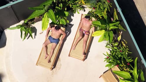 Men Relaxing on Loungers in a Tropical Outdoor Patio