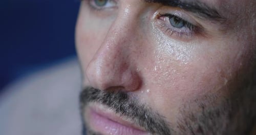 Nahaufnahme des Gesichts eines müden und verschwitzten Mannes, der gerade ein Training beendet hat und schwer atmet